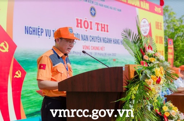 A person standing at a podium in front of a crowd of peopleDescription automatically generated with low confidence