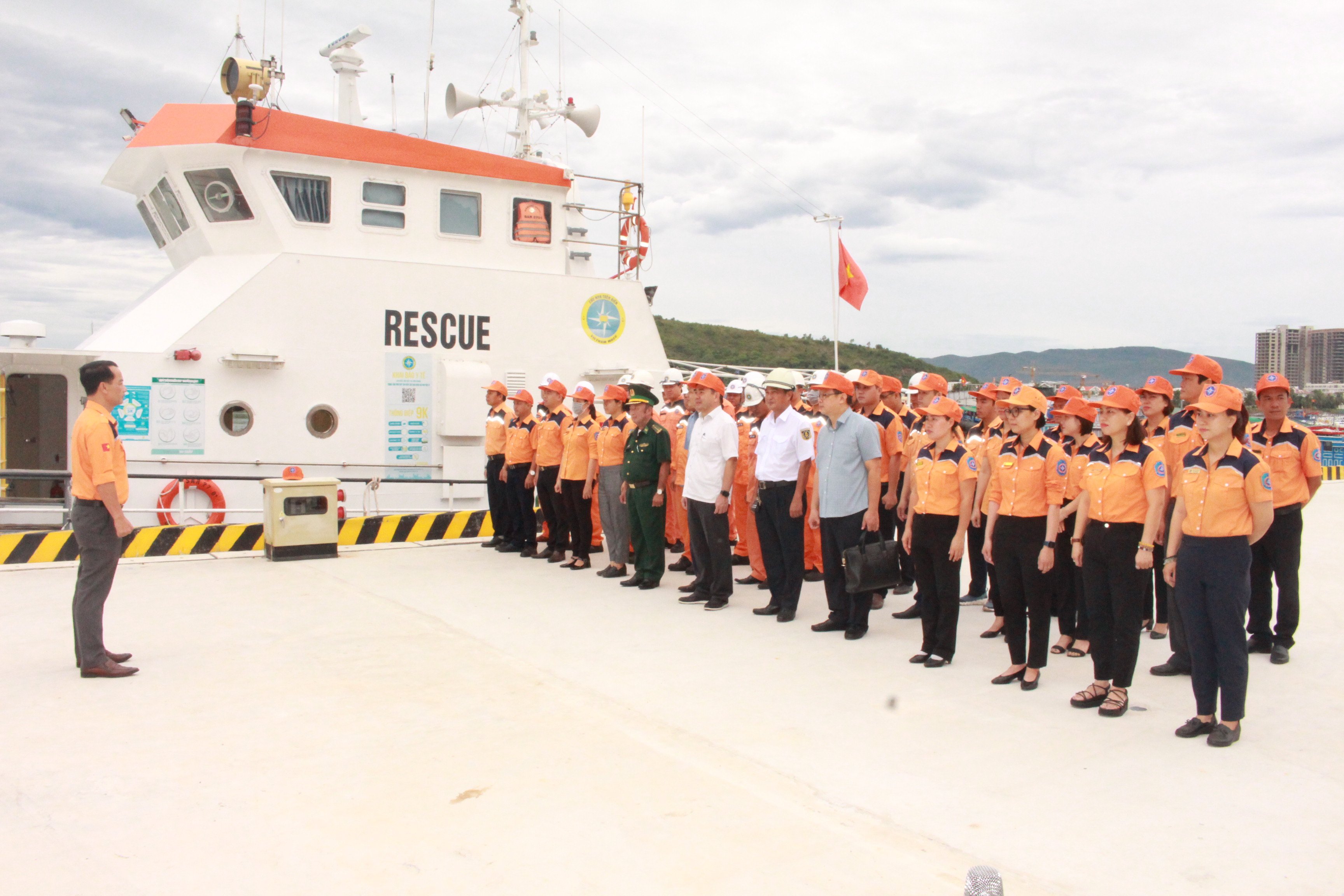 A group of people standing in front of a boatDescription automatically generated with medium confidence